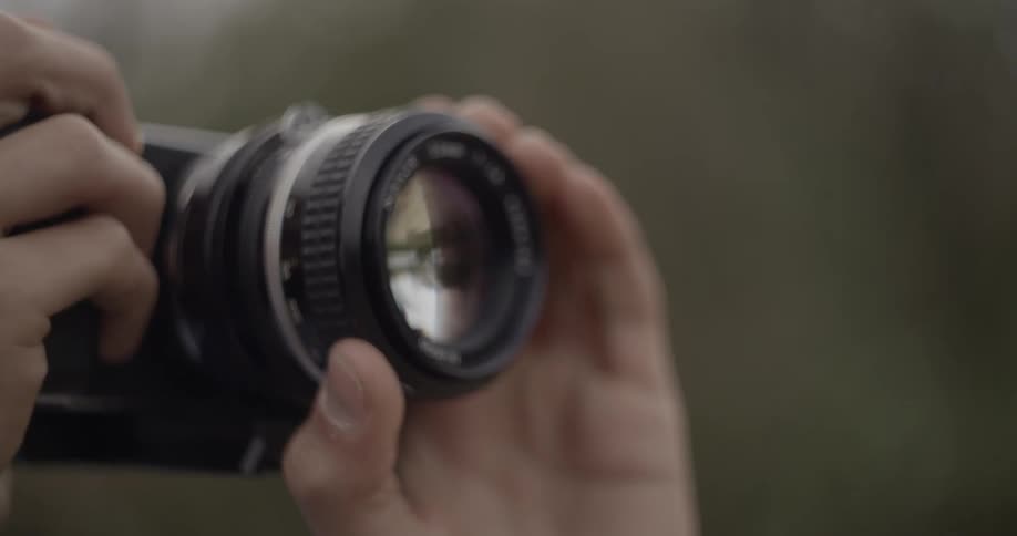 A person is adjusting the lens on their camera