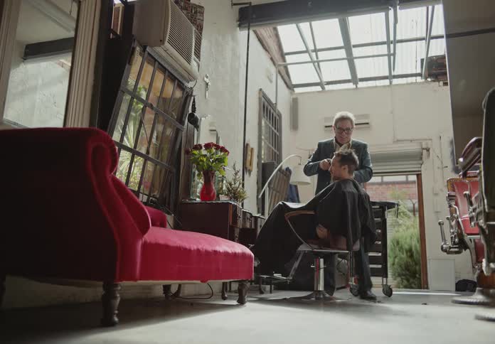 Barber giving a razor cut to his client