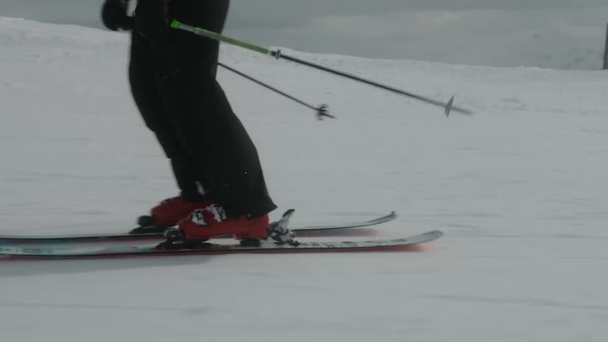 A skier doing tricks on the slope covered in snow on a cloudy day