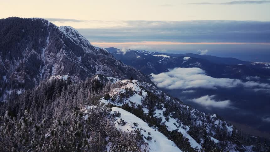 Panorama of a mountain range covered by snow and vegetation on a morning