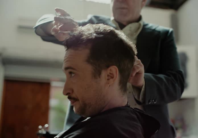 A barber cuts a clients hair