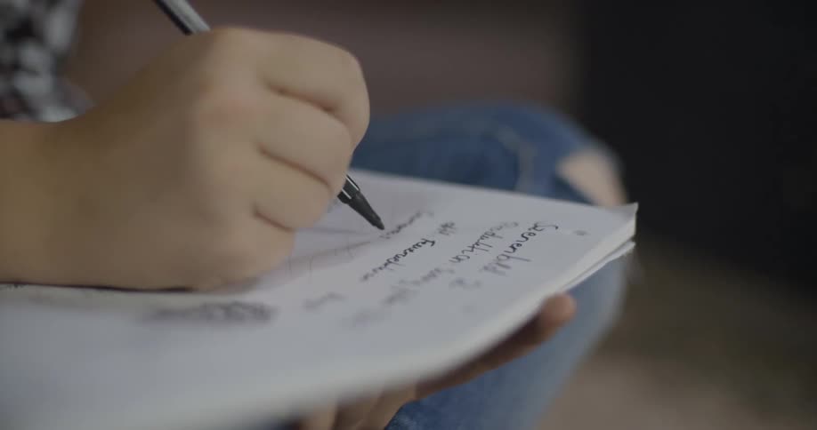 A person writes in a notebook