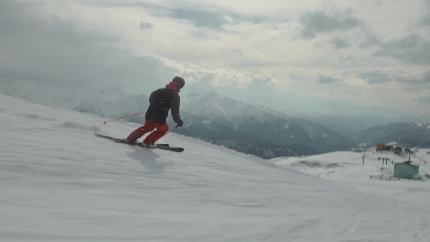 A person descending the snow mountain at high speed on a ski