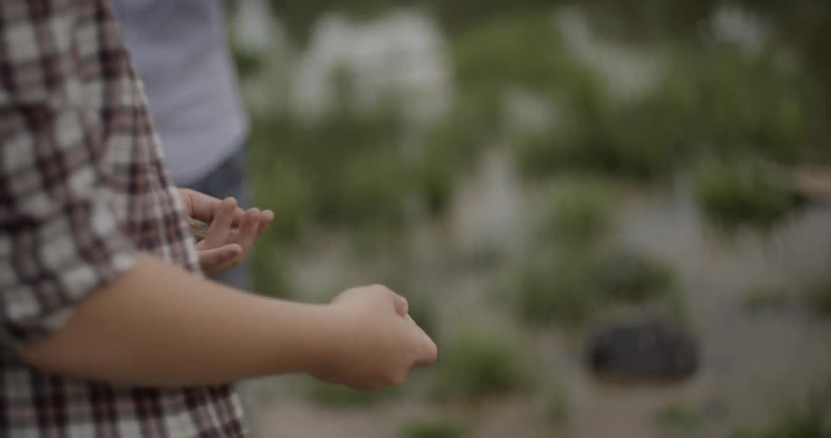 Person throws a rock gently up and catches in hand