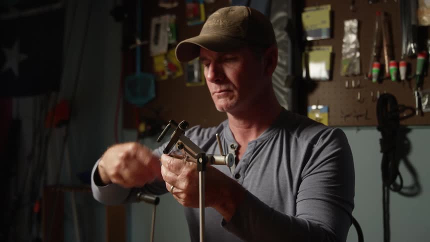 Portrait of a man holding a gauntlet and threading fishing line