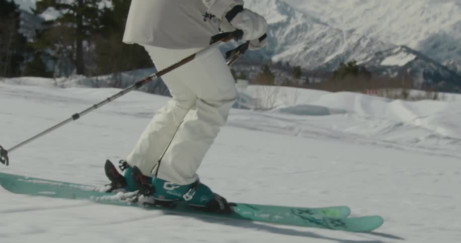 A person snow skis down a mountain in slow motion