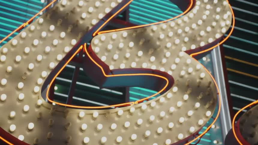 A rotating shadow moves across a sign lighted by many lightbulbs