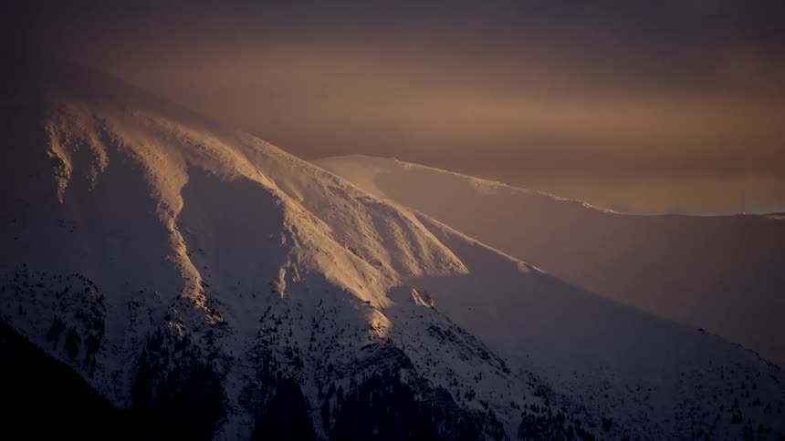 A huge mountain of rocks that is completely covered in snow