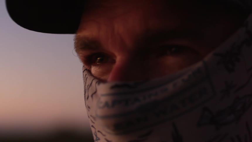 A persons face with their mouth covered with a cloth and the person is shaking and the wind is blowing on their face