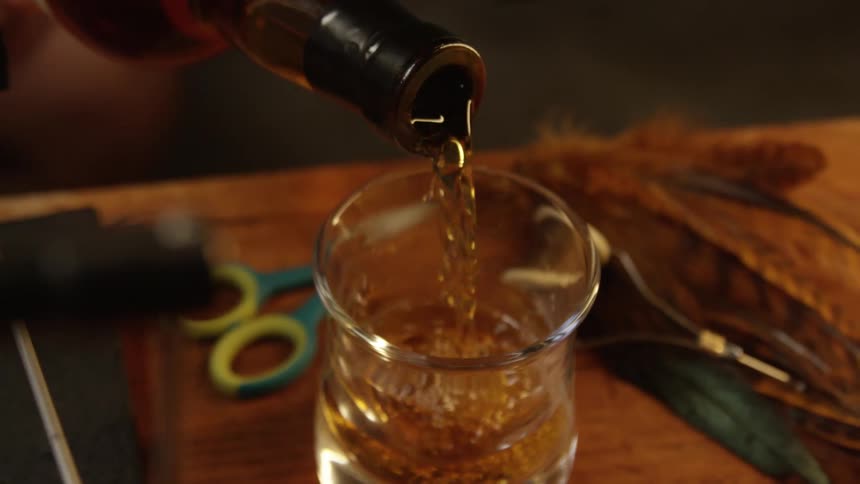 Alcoholic drink being poured into a glass cup