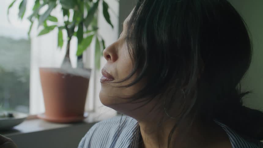 Side portrait of a young woman smoking indoors