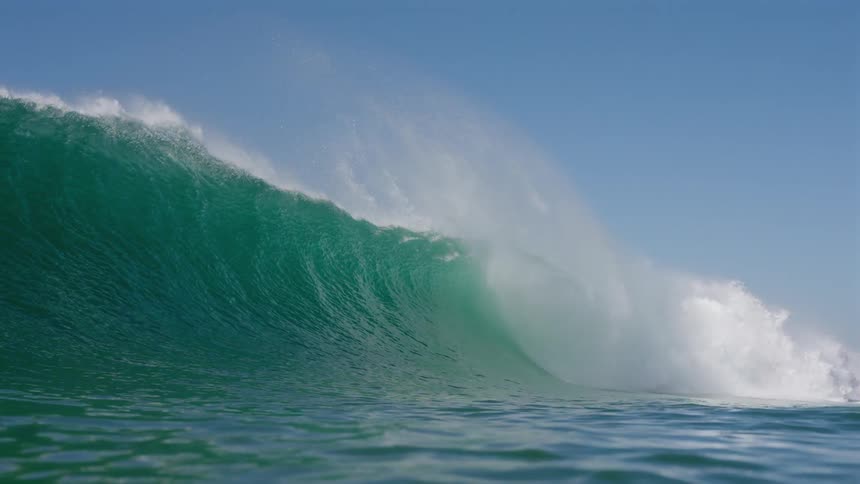 Waves breaking in a turquoise sea in slow motion