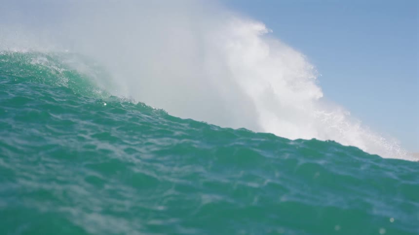Waves crashing on the ocean next to the coast during day time