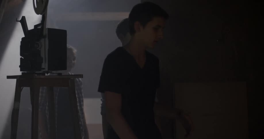 A trio of people walk into a dark room