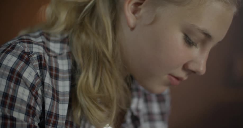 A young girl looks intently at something
