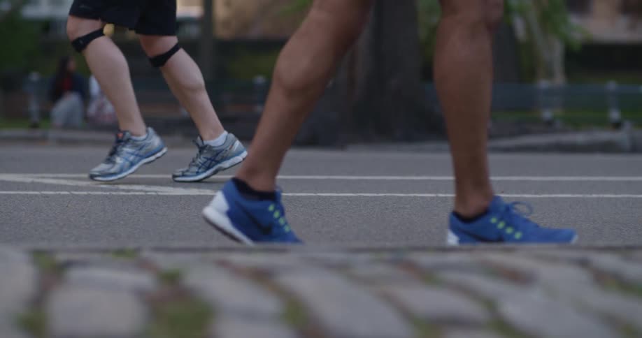 Two people run on the asphalt