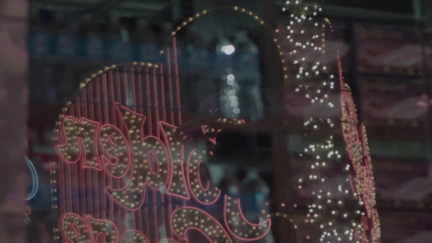 A reflection of a sign in las vegas with flashing lights