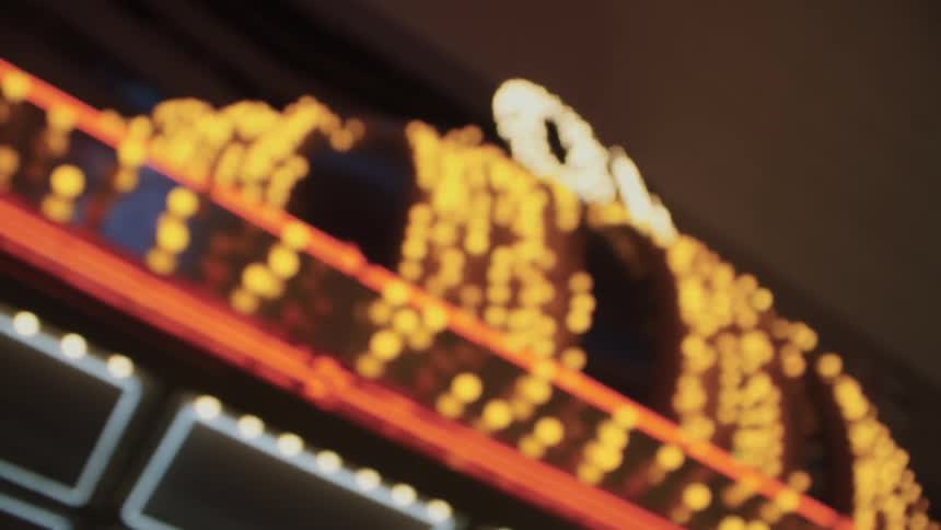 The lights of a sign are flashing at night