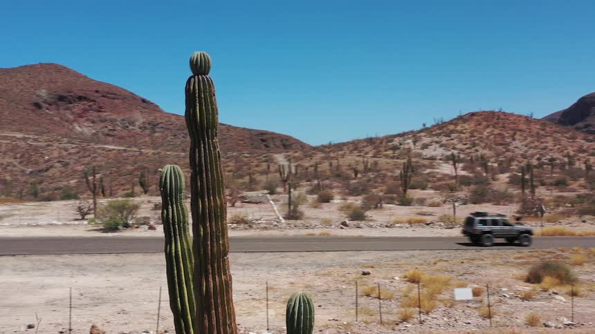An suv driving outdoors in the middle of a desert