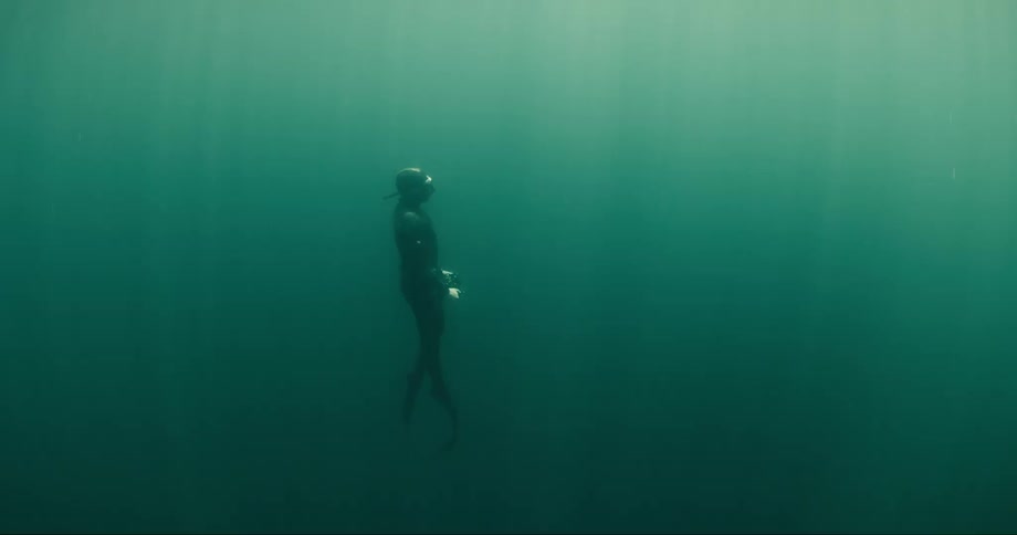 Diver rises through the murky water toward the surface