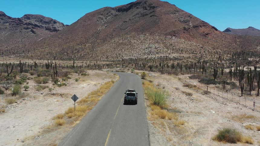 An atv gets back onto a desert road and drives off
