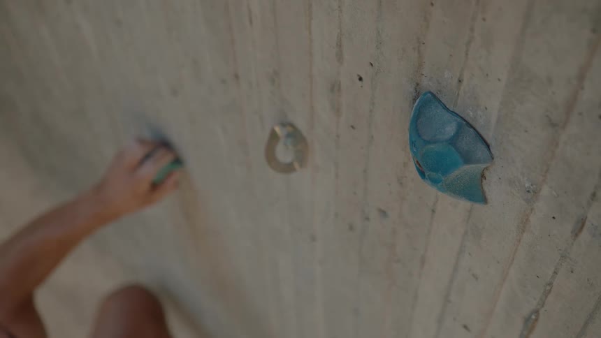 Man uses grips on rock climbing wall