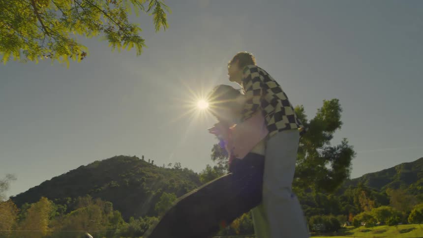 A woman falling into a mans arms outdoors