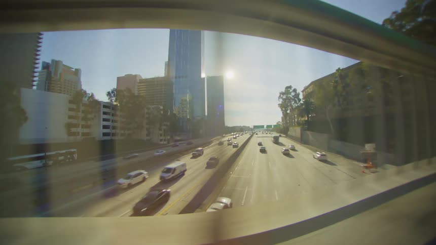 Traffic on the road of a metropolitan city seen through the handrail of a bridge during day time