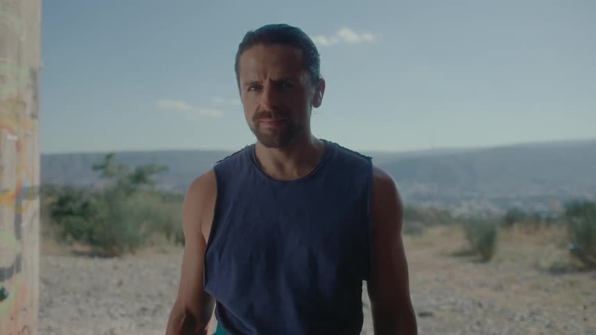 A portrait of a man on a blue singlet