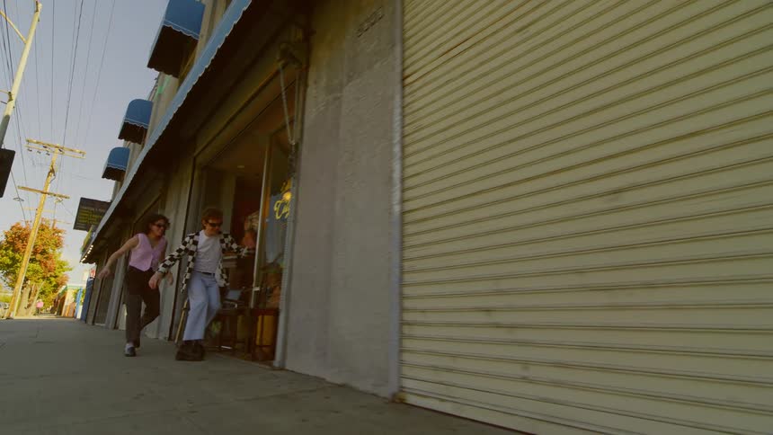 Couple running along a sidewalk happily and sitting on a bench in a store