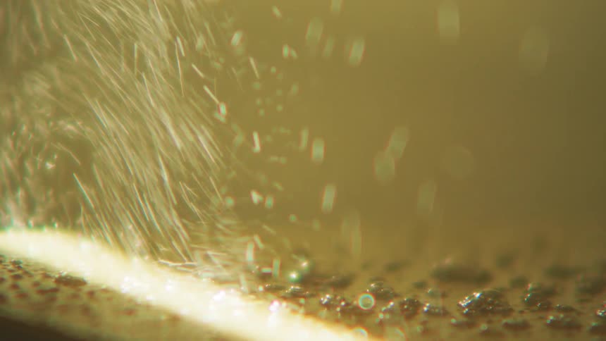 Water sprays over a white bar and pushes away dirt
