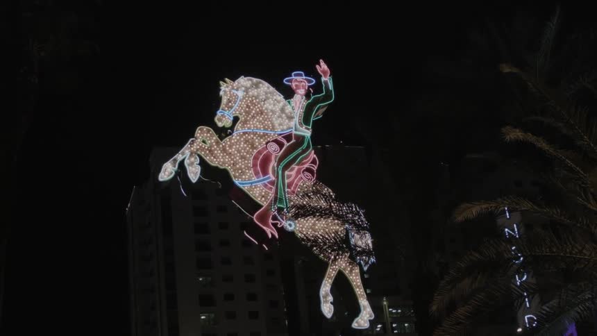 A lit up horse sign sparkling at night