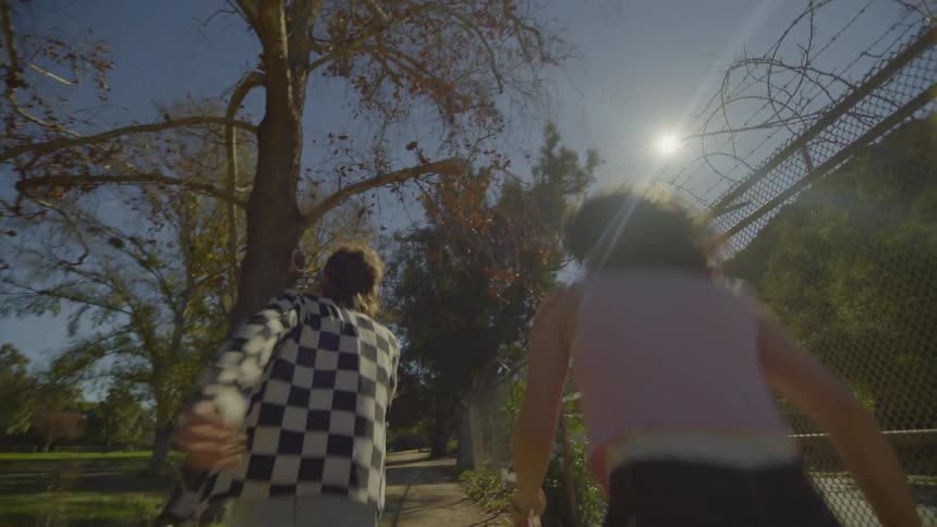 A man and a woman run down a sidewalk