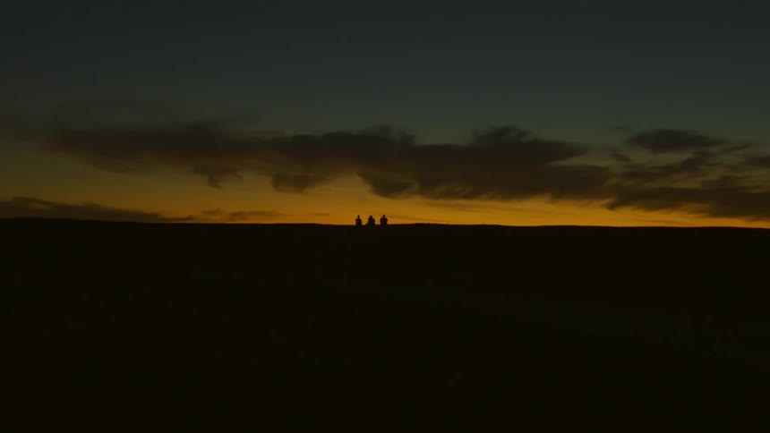 A night clip of three friends sitting and watching as night falls