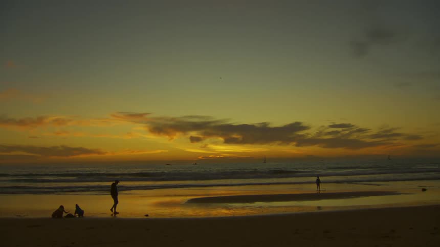 A plane flies over people on the beach