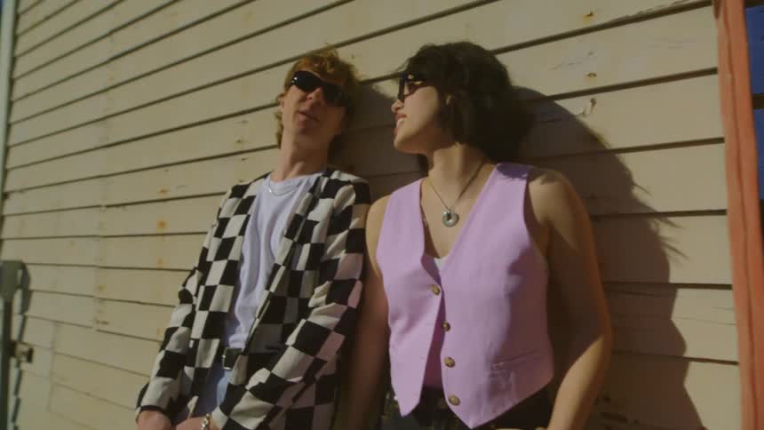 A man and woman standing outdoors on a sunny day