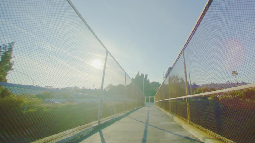 Walkway on a viaduct with fences around it on a sunny day