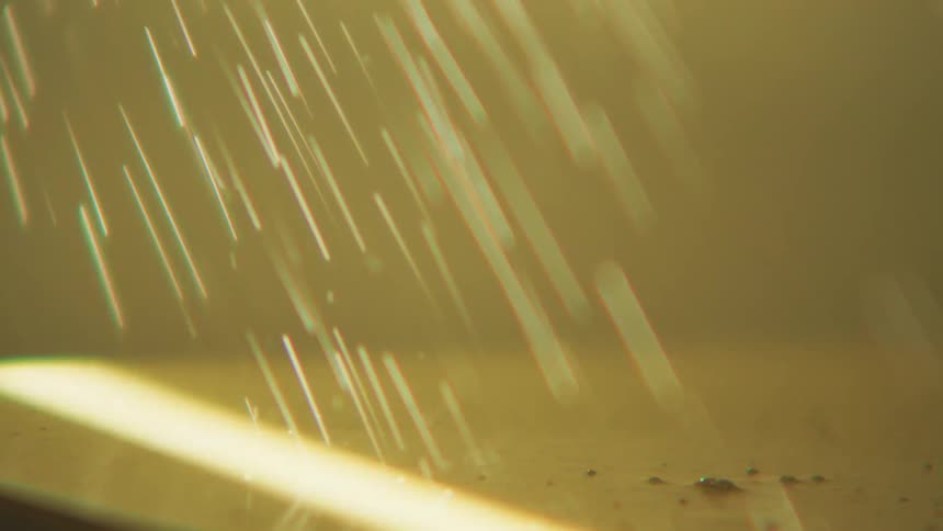 Extreme close up on water droplets falling on a surface