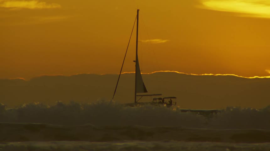 Sailing boat surrounded by sea waves at the sea during dusk or dawn