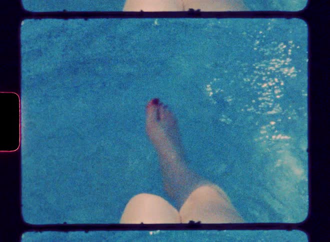 A persons legs are in the water and moving and their toenails are painted