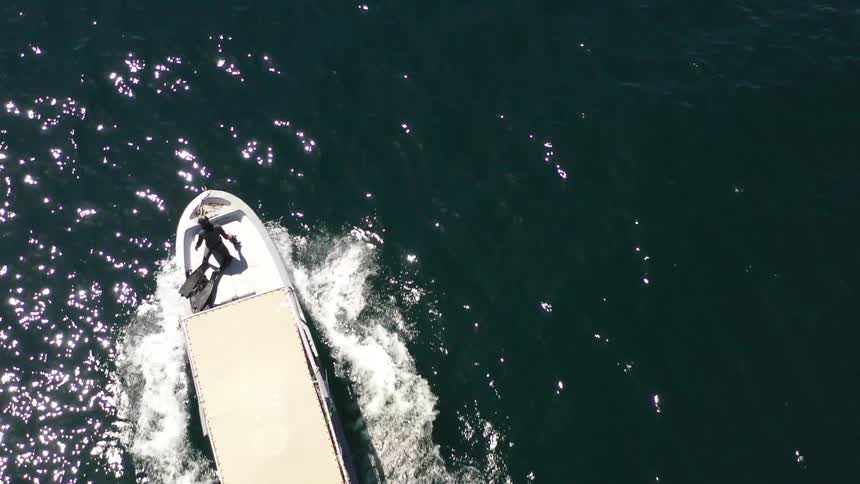Top view of a small motorboat in motion amidst the sea