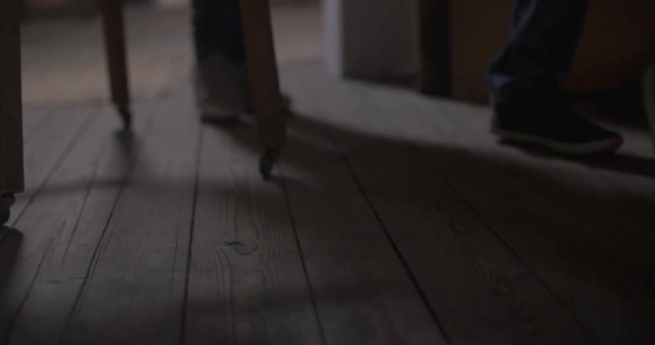 Feet walk across a wood floor