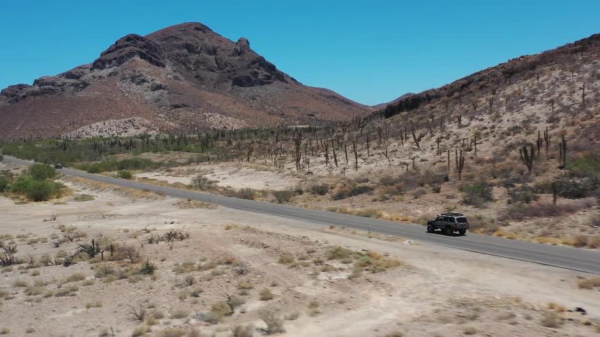 An suv driving on a lonely road in the middle of nowhere