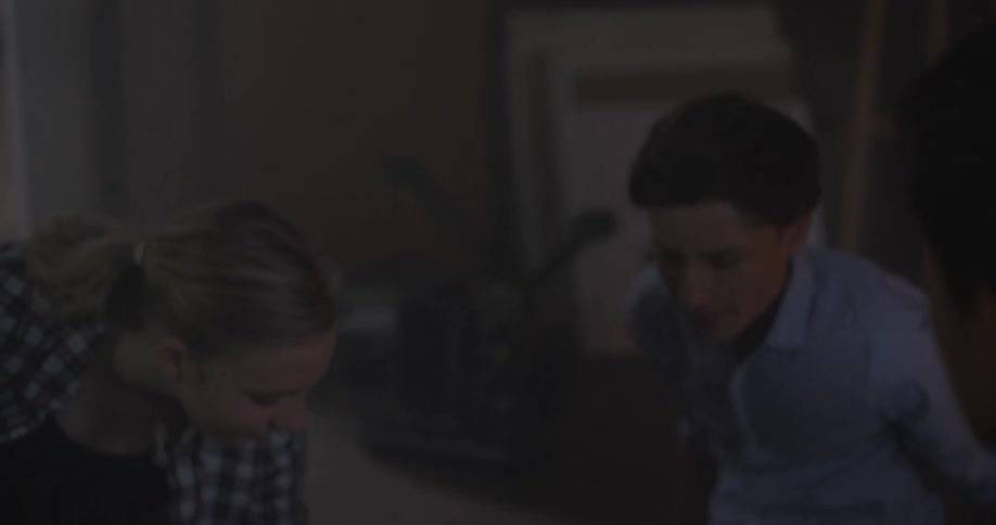 A group of people sit in a dim room