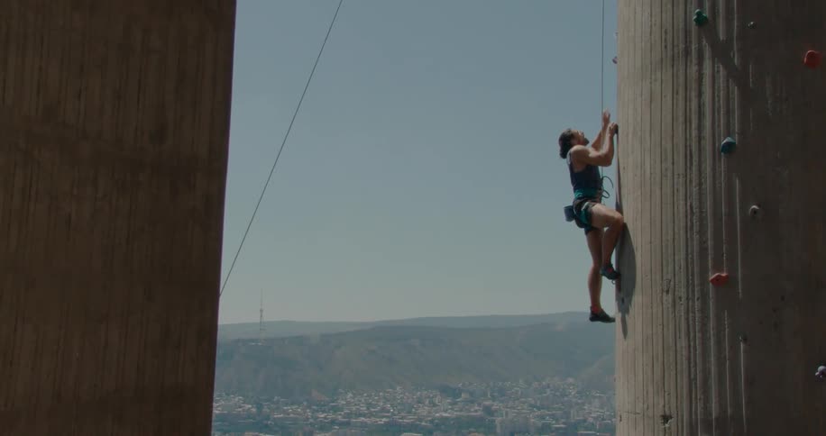 A man is climbing the side of a wall