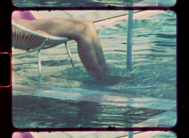 Person sits in chair placed in swimming pool and splashes their legs in the water