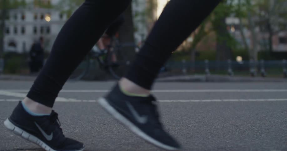 A bicyclist goes one way while a jogger goes another on a city street