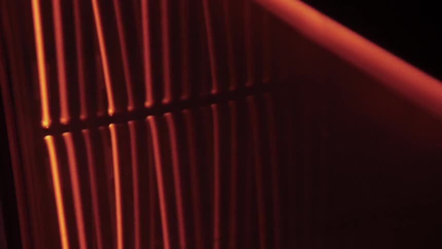 The light is coming in from the window shining in the blinds