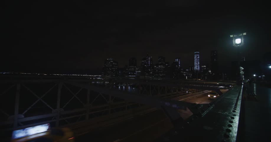 Cars are driving over a bridge at night