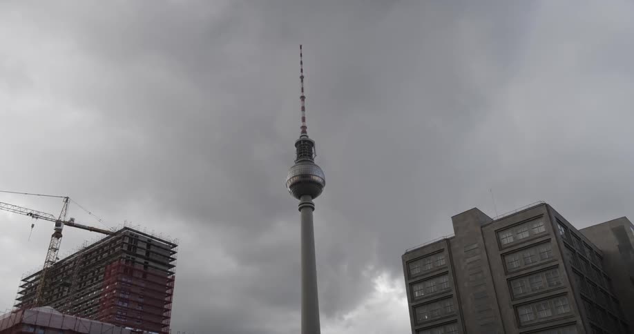 A pillar is in between some buildings on a cloudy day